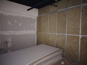 wall battens filled with insulation , with sheets of plaster on the floor