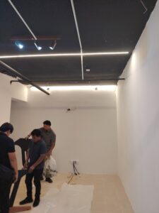 3 men holding parts to assemble the masterint console
