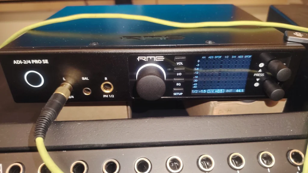 Front view of the RME Audio ADI 2/4 Pro SE with a green headphone cable coming out of headphone 1